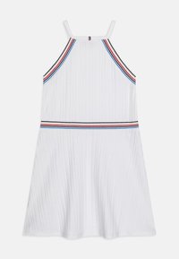 Biała sukienka bez rękawów o teksturze prążkowanej, z poziomymi paskami w kolorach czerwonym, niebieskim i czarnym w okolicy dekoltu i talii.