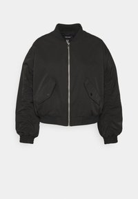 Černá zkrácená bomber bunda s předním zipem, bočními kapsami, staženými detaily na rukávech a náplety na manžetách a spodním lemu. Hladká textilie.