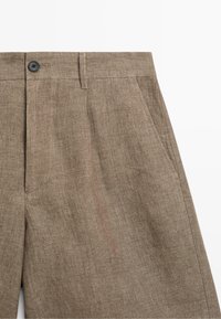 Braune Leinenhose mit Frontknopf, Gürtelschlaufen und seitlichen Taschen, zeigt obere Vorderansicht und Struktur.