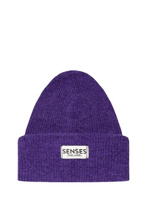 Purple knitted beanie hat with folded cuff featuring a white rectangular label reading "SENSES THE LABEL" stitched on front.