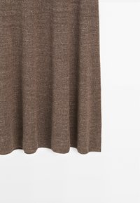 Bruine gebreide stof, zachte textuur, valt met zachte golven. Eenvoudig ontwerp, effen kleur, geen duidelijke patronen of hardware zichtbaar.