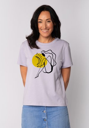 Licht lavendelkleurig katoen t-shirt met een zwarte lijntekening van een figuur en een gele zongrafiek. Korte mouwen, ronde hals ontwerp.