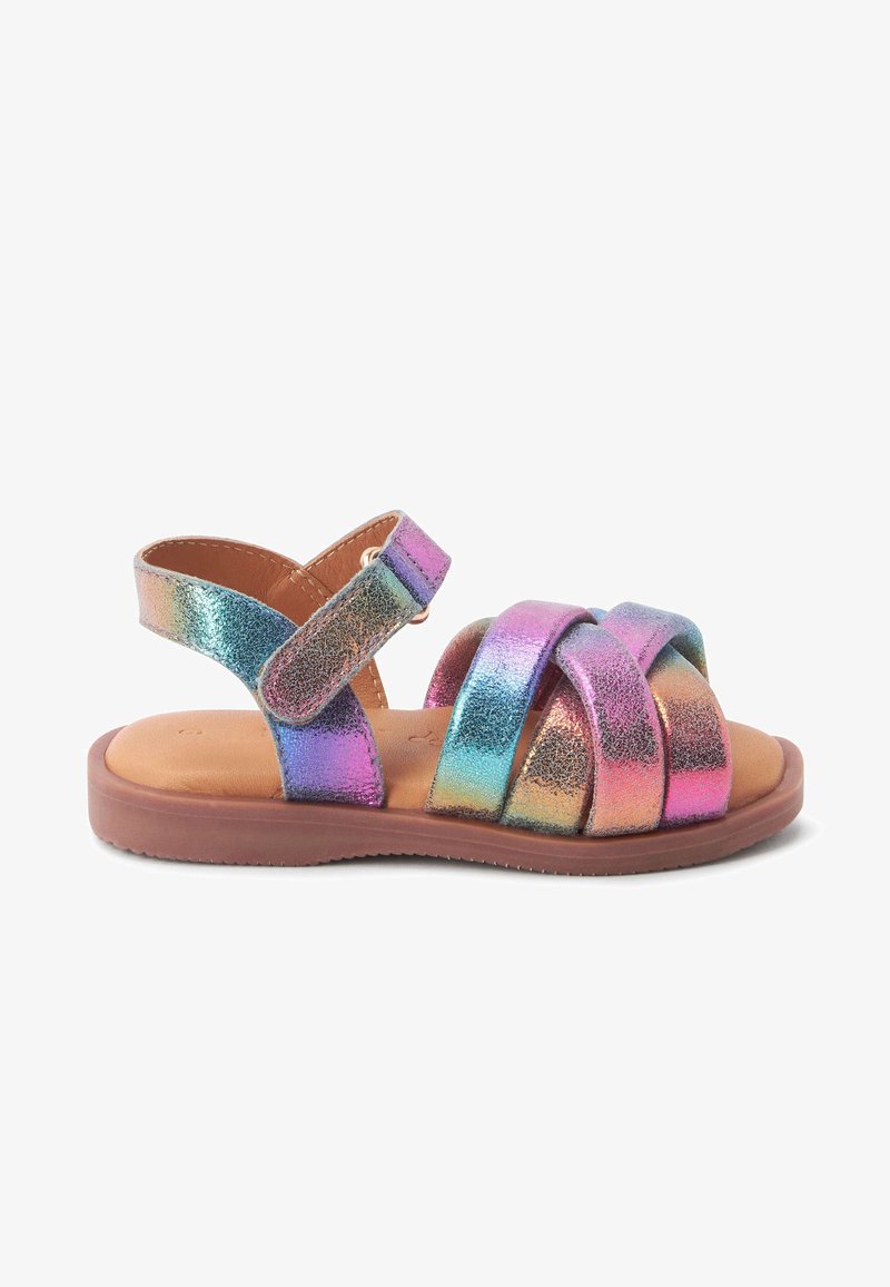 Sandale pour enfant avec brides métalliques arc-en-ciel, Velcro ajustable à la cheville et semelle marron rembourrée.