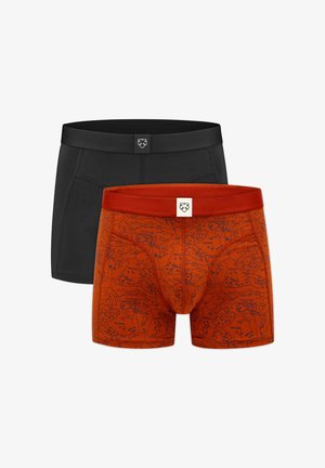 Kaks meestele mõeldud bokserit, üks üleni must ja teine oranž tumeda abstraktse kaardimustriga, mõlemal väiksed logoga sildid vöökohal.