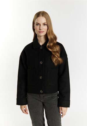 Giacca cropped in cotone nero con colletto, chiusura a bottoni e due tasche frontali. Presenta una superficie testurizzata e una vestibilità strutturata.