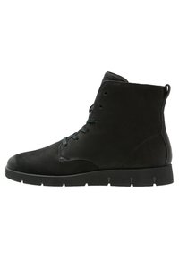 Stivale alla caviglia in suede nero con lacci frontali, linguetta sul tallone e suola piatta in gomma con battistrada scanalato.