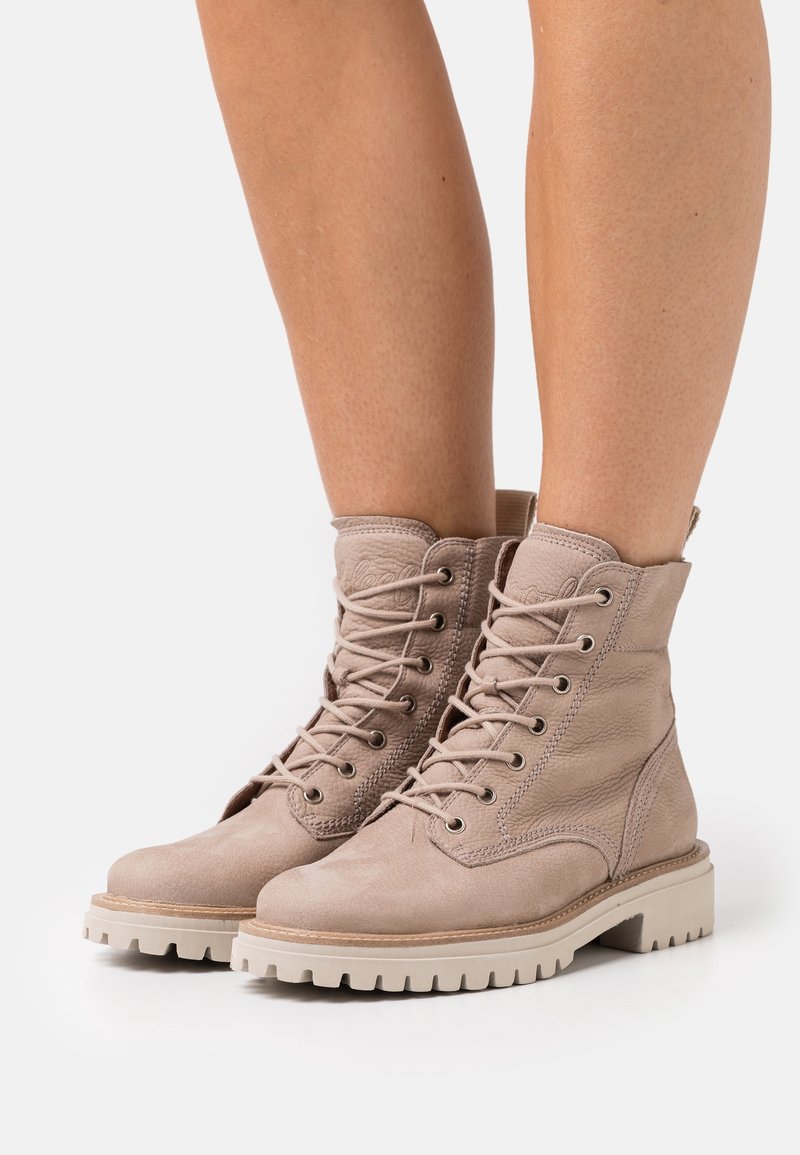 Bottes beiges à lacets en cuir texturé, avec un col rembourré, un bout rond et une semelle en caoutchouc robuste à profil profond.