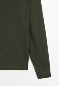 Maglione verde scuro realizzato in morbida lana, con un motivo a maglia strutturato, polsini a coste e orlo dritto.