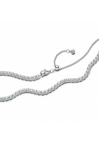 Ogrlica v srebrni barvi z vrsto prozornih, okroglih kamnov, nastavljenih v prstnem nastavku, z zaponko s pomočjo jastreba in nastavljivo verigo.