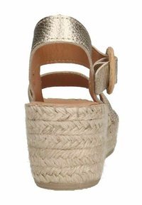 Schoenen met een metallic gouden faux leren bovenkant, enkelband met een ronde houten gesp en een geweven jute platform hak.