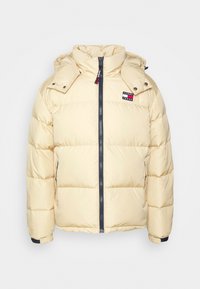 Doudoune jaune avec capuche, dotée d'une fermeture éclair frontale, de poches latérales et d'un patch logo. Texture lisse avec un design matelassé.