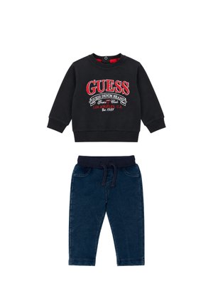 Felpa nera a maniche lunghe per bambino con logo rosso "GUESS" e pantaloni blu con elastico in vita e coulisse.