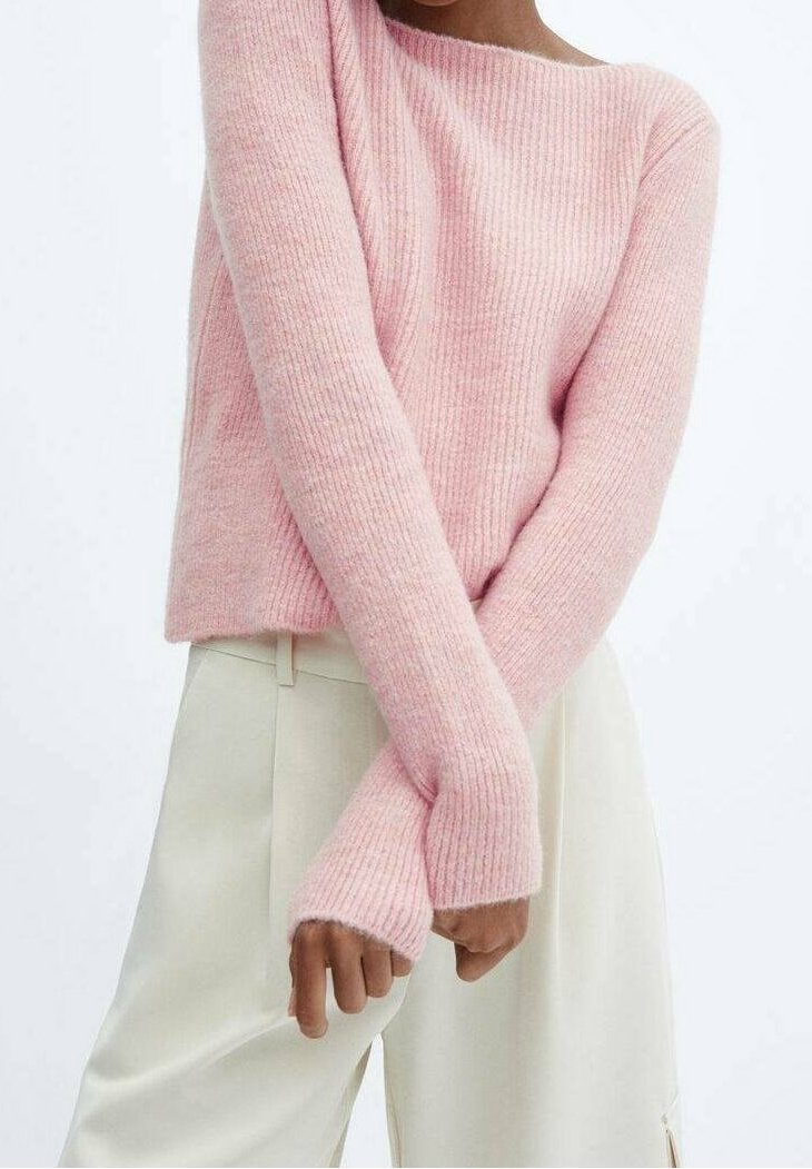 Pull en tricot rose avec texture côtelée, décolleté ample et manches longues. Assorti à un pantalon crème, offrant une coupe décontractée.