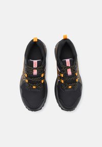 Baskets de sport noires avec un tissu texturé et des semelles en caoutchouc. Caractéristiques des accents orange et violet ainsi que des lacets à motifs. Support de cheville rembourré.