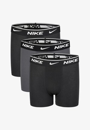 Trys Nike bokserio šortų poros juodos, tamsiai pilkos ir vidutiniškai pilkos spalvų, su elastingomis juosmens juostomis, ant kurių yra Nike logotipas.