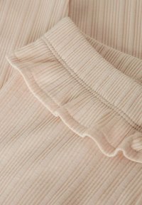 Lichtroze stof met subtiele verticale strepen, voorzien van een gerimpelde kraag. Zachte textuur met een delicate, lichte uitstraling.