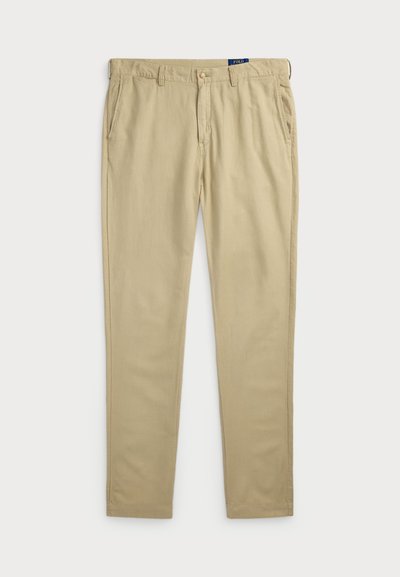 Calças de algodão bege com um design de perna reta, apresentando bolsos laterais e um fecho de botão na frente. Textura suave e costura mínima.