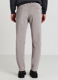 Pantaloni in velluto a coste grigi con vestibilità dritta, caratterizzati da un tessuto testurizzato, due tasche posteriori e abbinati a scarpe nere.