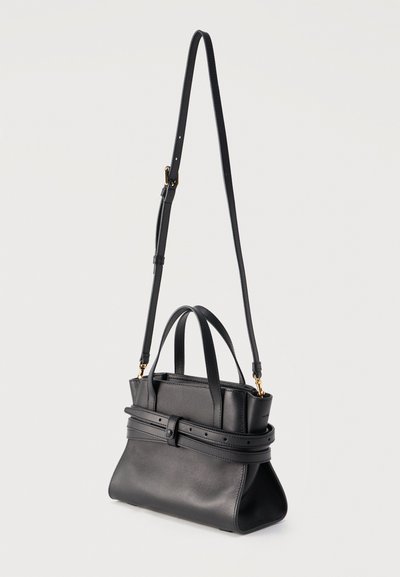 Sac à main en cuir noir avec deux poignées courtes, une longue bandoulière ajustable et un détail de ceinture décorative autour du corps.