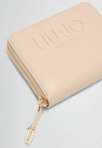 Portafoglio testurizzato color crema con zip e hardware dorati. Presenta il logo in rilievo "LIU·JO MILANO" sulla superficie. Design compatto e rettangolare.