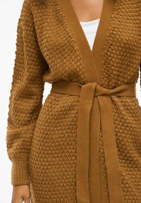 Cardigan en tricot marron avec un motif texturé, doté d'un décolleté en V profond, de manches longues et d'une ceinture assortie à la taille.