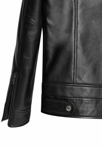 Zwarte leren jack met een textuurafwerking, ritssluiting bij de manchetten en drukknoopsluiting in de taille. Strak ontwerp met subtiele stikseldetails.