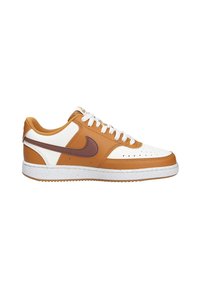 Baskets Nike avec un revêtement supérieur en cuir blanc et beige, accents marron, boîte à orteils perforée, devant à lacets et semelle extérieure en caoutchouc texturé.