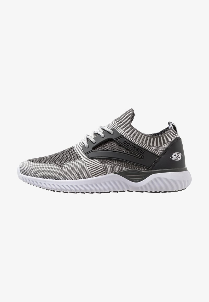 Scarpa sportiva grigia in maglia con collare a coste, dettagli neri e suola bianca texturizzata. Presenta lacci e un dettaglio con il logo sul tallone.