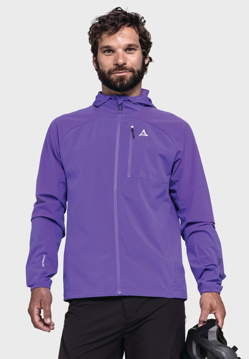 Lila wasserdichte Jacke mit einem Reißverschluss vorne, verstellbare Kapuze und elastischen Bündchen. Verfügt über eine Brusttasche mit einem Logo. Getragen über schwarzen Hosen.