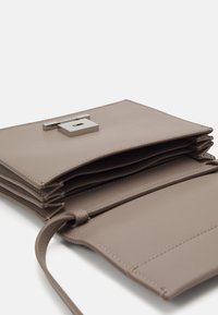 Grijs gestructureerde leren portemonnee met een metalen sluiting, voorzien van meerdere kaarthouders en een eenvoudig ontwerp. Geopend om de binnenvakken te tonen.