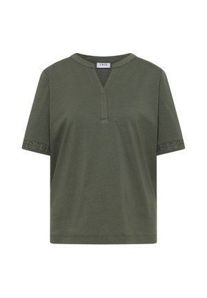 Chemise vert olive à manches courtes avec col en V et détails en dentelle aux poignets, étiquetée « CECIL » à l'intérieur de l'encolure.