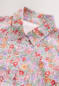 Srajca z rožnim vzorcem, vijoličastim ozadjem in rdečimi, oranžnimi ter zelenimi poudarki. Model na gumbe s klasičnim ovratnikom. Mehka tekstura tkanine.