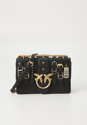 Borsa a tracolla in pelle nera con hardware color oro, dotata di una tracolla a catena, motivo a cappotto in rilievo, e vari strap e borchie decorative.
