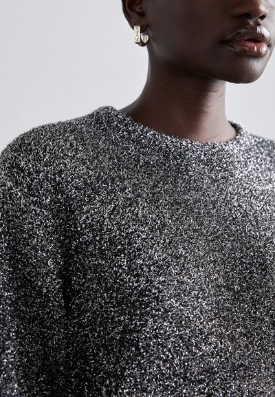 Sølv, struktureret sweater med rund halsudskæring og løs pasform, der har skinnende fibre. Kombineret med en guldfarvet geometrisk ørering.