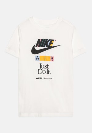Biała koszulka z krótkim rękawem z wielokolorowym logo Nike, czarnym znakiem Swoosh, napisem "AIR" w kolorowych blokach, tekstem "Just Do It." oraz danymi firmy poniżej.