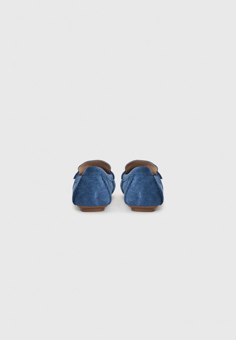 Blaue Wildleder-Mokassins mit runder Zehenform und minimalen Nähdetails. Die Sohle ist braun und bietet einen Kontrast zum Obermaterial.