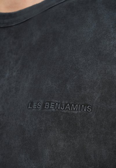 Črna bombažna majica s sprano teksturo in subtilnim vezenim logotipom z napisom "LES BENJAMINS" na sprednji strani.