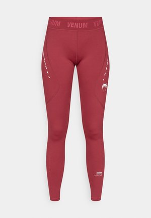 Rote Leggings mit nahtlosem Design, Venum-Logo auf dem Bund, texturierter Naht und weißem Muster an der Seite. Dehnbarer Stoff.
