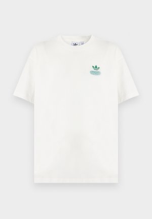 Bijela majica kratkih rukava s malim zelenim Adidas logotipom i tekstualnim detaljem na gornjem lijevom dijelu prsa.