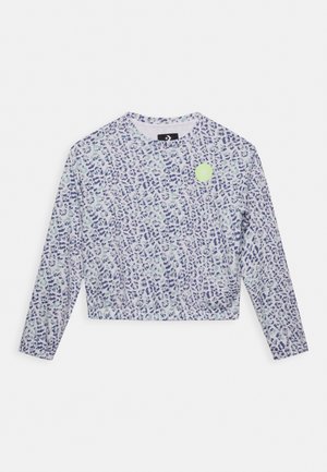 Langærmet cropped skjorte med blå og lysegrøn leopardprint og en lille rund grøn grafik nær venstre skulder.