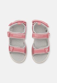 Pink sandals with adjustable straps, textured gray insole, rubber soles, and logo accents on the straps. Lightweight design for comfort.