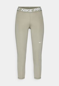 Nike Pro legging in licht olijfgroen, met een brede elastische tailleband met de tekst "NIKE PRO" en een subtiel logo op het onderbeen.