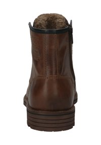 Braune Leder-Stiefeletten mit einem weichen Futter am Kragen, seitlichem Reißverschluss und einer strukturierten gummierten Sohle mit sichtbarem Profil.