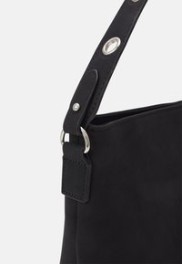 Bolso de ante negro con forma plana, que presenta un acento de hardware plateado en la correa para el hombro y un detalle cosido cerca del clip.