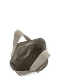 Sac fourre-tout en suède gris avec deux poignées supérieures, comprenant une poche zippée intérieure et deux poches à glissière, texture douce et design à large ouverture.