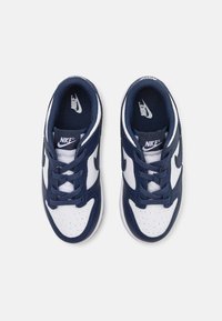 Sötétkék és fehér Nike sneaker bőr és textil felsőrésszel, kerek orral, perforált részletekkel és klasszikus fűzős záródással rendelkezik.