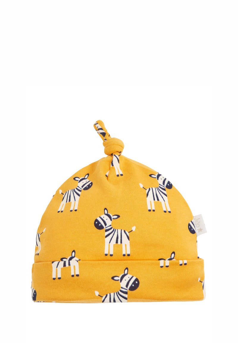 Keltainen puuvillahattu, jossa on solmu päällä, ja se näyttää musta-valkoisia seepra-kuvioita tasaisella taustalla. Pehmeä rakenne.