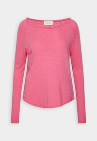 Long-sleeve pink top with a rounded neckline, made of lightweight fabric; features a slightly curved hem and subtle texture.