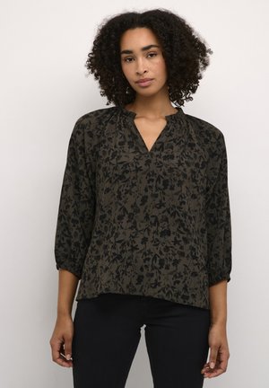 Blouse à motif floral sombre avec une coupe décontractée, des manches trois-quarts et un décolleté en V. Fabriquée en tissu léger avec une surface texturée.