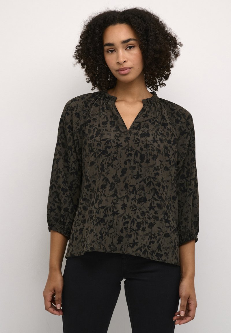 Blouse à motif floral sombre avec une coupe décontractée, des manches trois-quarts et un décolleté en V. Fabriquée en tissu léger avec une surface texturée.